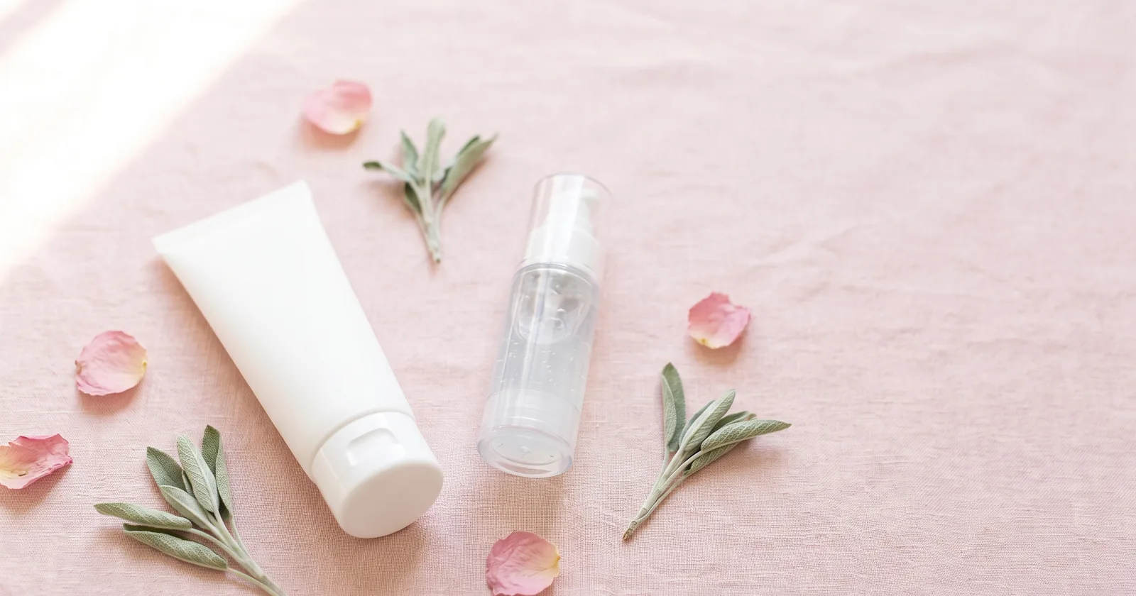 Azelaic acid before and after guide with a white cream tube and clear gel pump on blush pink beside rose petals and sage sprigs